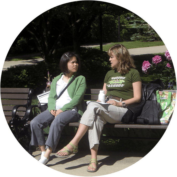 Two women sitting on bench, talking