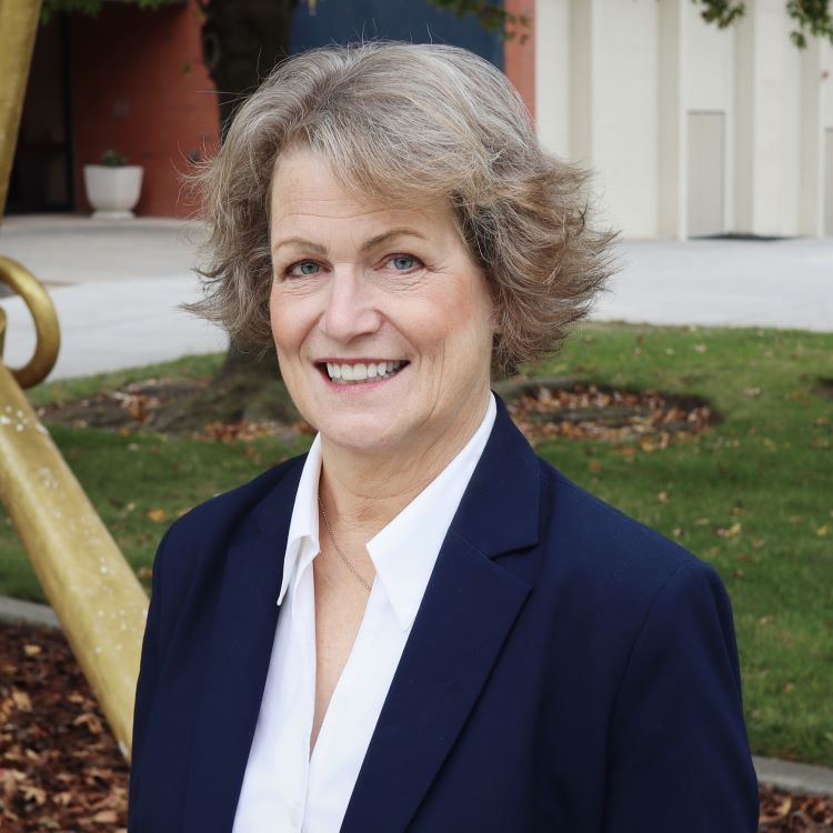 Lori Schroeder outdoors in a navy blazer and white blouse
